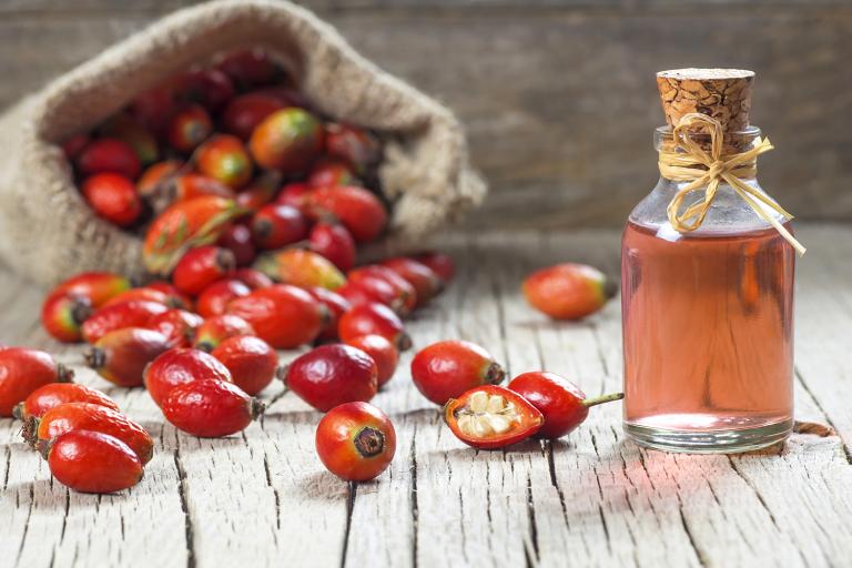 dried rosehip fruit and a bottle of rosehip oil