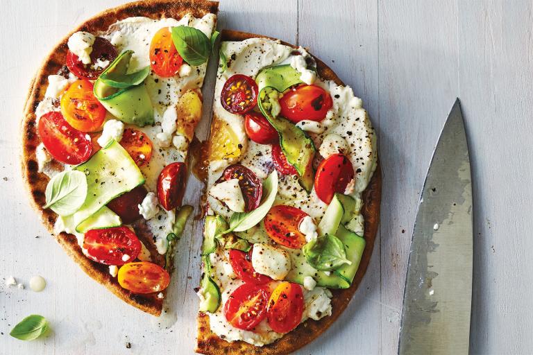 Ricotta and Zucchini Flatbread on a white washed wooden table.